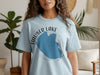 Light blue t-shirt with "Hauser Lake Idaho" text and lake outline graphic.