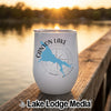 White stemless travel tumbler with Canyon Lake Arizona map and compass design resting on a wooden dock.