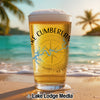 Beer glass with "Lake Cumberland" and compass design on a beach.