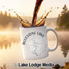White mug with "Bluestone Lake West Virginia" and compass design, coffee pouring in.