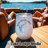 A white travel tumbler featuring a New Hogan Lake California design sits on a wooden boat table.