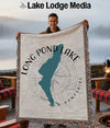 Man holding a woven blanket featuring a teal outline of Long Pond Lake, New Hampshire.