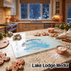 A glass cutting board featuring a blue map design rests on a kitchen counter amidst holiday baking supplies.
