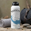 White water bottle with "MARION" and map design, beside rolled towel and bag.