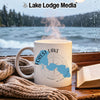 White mug with Forest Lake, Minnesota map and compass graphic beside a book and scarf.