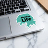 Teal sticker on laptop with black text "Hefner Life" and "Lake Lodge Media LLC".
