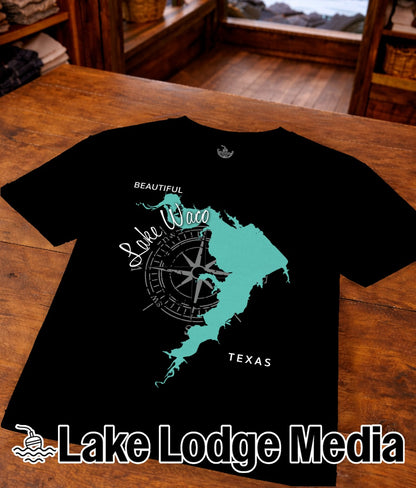 Black t-shirt featuring a turquoise outline of Lake Waco with a compass rose and "Lake Lodge Media" text.