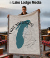 Man holding a blanket with Lake Michigan outline and compass graphic.