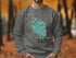 Gray sweatshirt with teal Lake Tapps Washington graphic and compass rose.